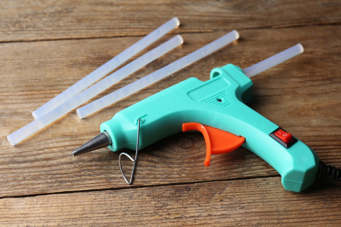 Hot Glue Gun and Sticks on Wooden Table
